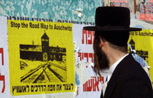 An Israeli man looks at a poster reading 'stop the road map to Auschwitz'